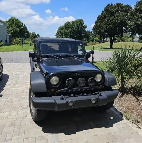Black Jeep Wrangler parked on a paver driveway for a residential pickup in Altamonte Springs