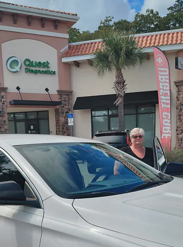 White sedan at the Quest Diagnostics storefront in Orlando with a woman stepping out of the passenger side
