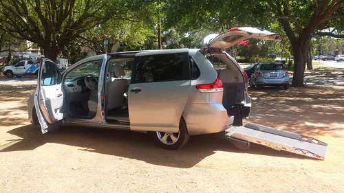 Comfort Ride Transportation wheelchair van with its rear ramp lowered on a pickup in The Villages