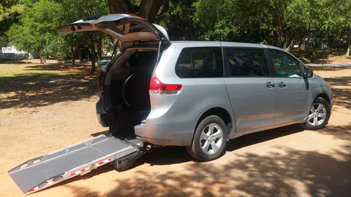 Silver Comfort Ride Transportation minivan with the rear wheelchair ramp folded out in The Villages