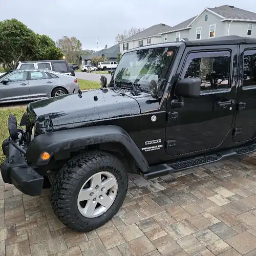 Black Jeep Wrangler parked on a wet brick driveway for a residential pickup in Lake Mary