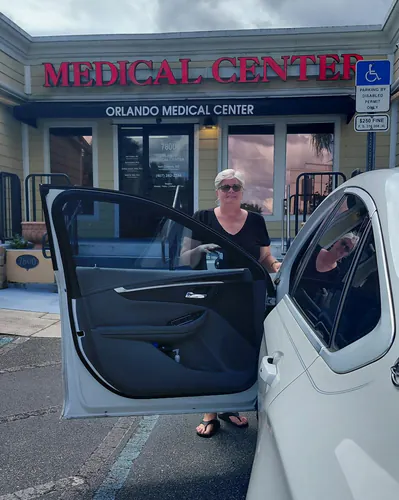 White sedan with the passenger door open at the entrance of Orlando Medical Center