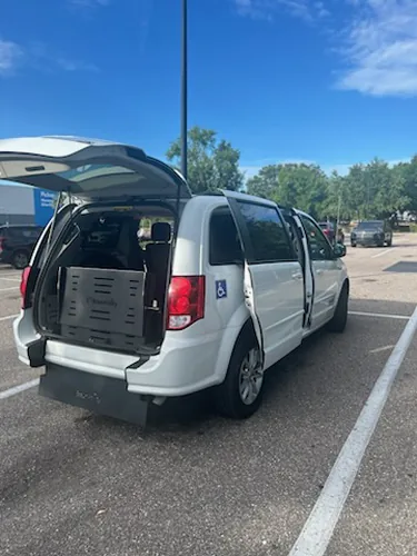 Comfort Ride Transportation wheelchair accessible van with the hatch open and ramp stowed in a Gainesville parking lot