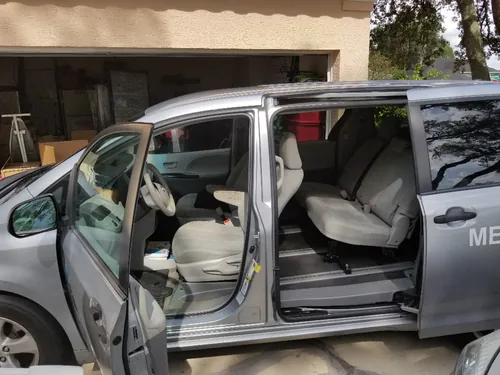 Inside view of a silver Comfort Ride Transportation Toyota Sienna with the side door open in an Ocala driveway